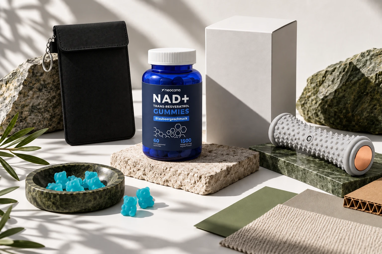 NAD+ Gummies mit Blaubeergeschmack, Handyschutztasche und Massagerolle auf Stein- und Materialmustern
